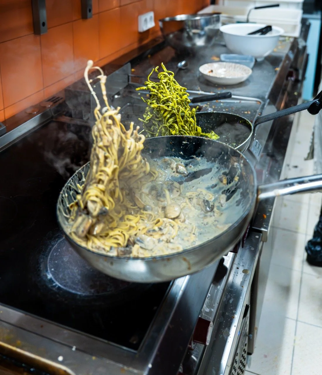 Poêle avec des pâtes qui cuisent, la vapeur s'échappe dans une cuisine.