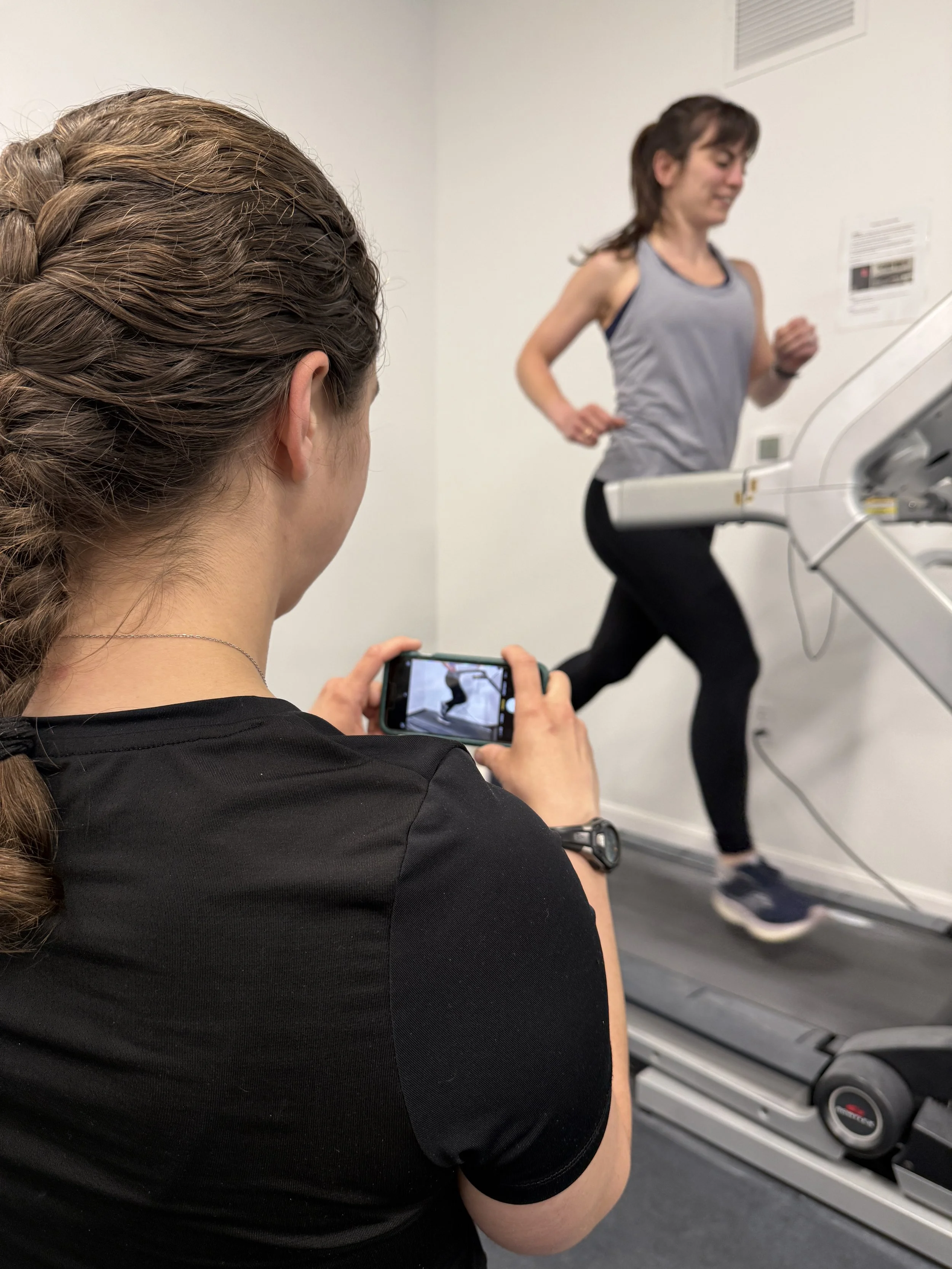 Physical Therapist takes a video of patient running on the treadmill for running gait analysis