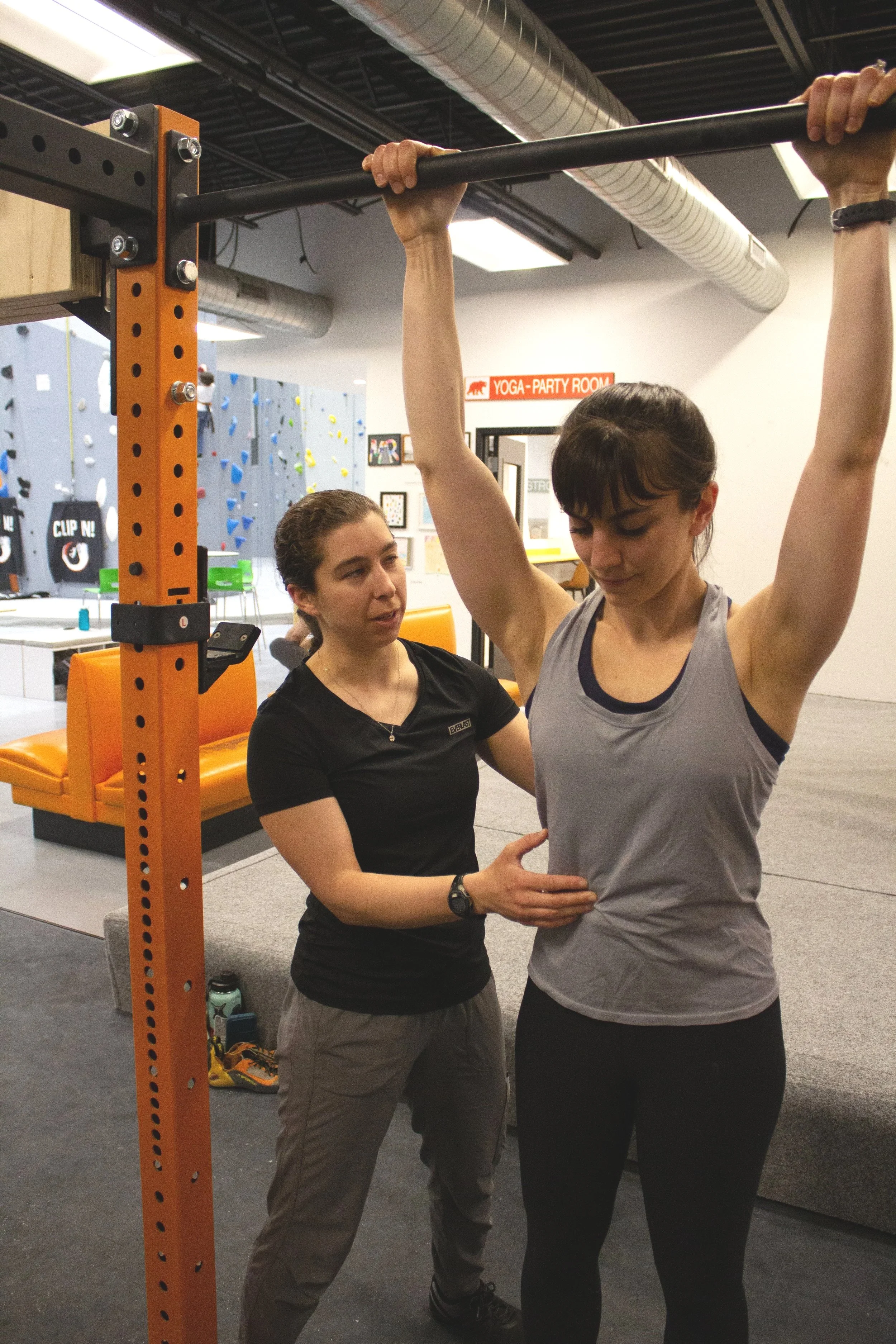 Physical Therapist coaches patient through a pull up exercise