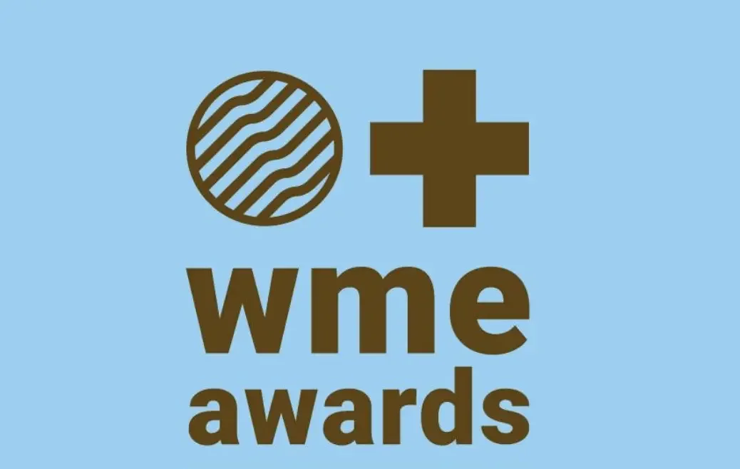 A graphic with a blue background featuring a stylized globe and a plus sign, with the words "wme awards" in bold brown letters.