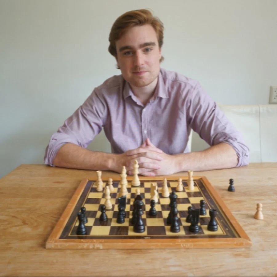 Matthijs, van Schaken met Matthijs en het YouTube kanaal Matthijs Chess, zit achter een schaakbord.