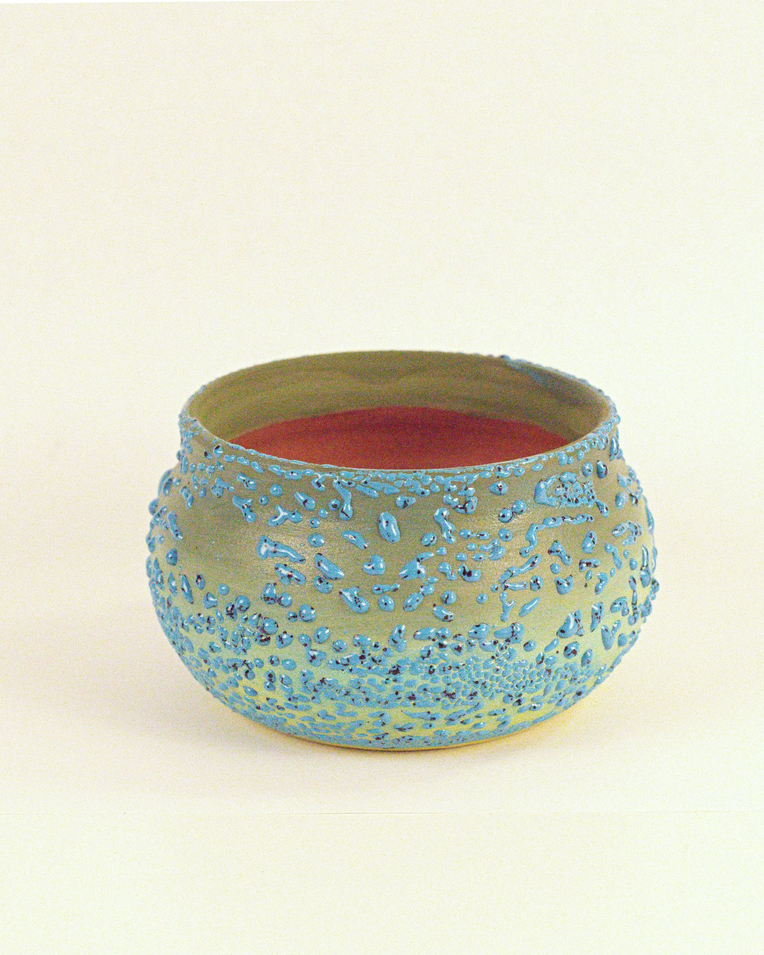 Decorative ceramic vase with blue texture beads over grean underglaze. 