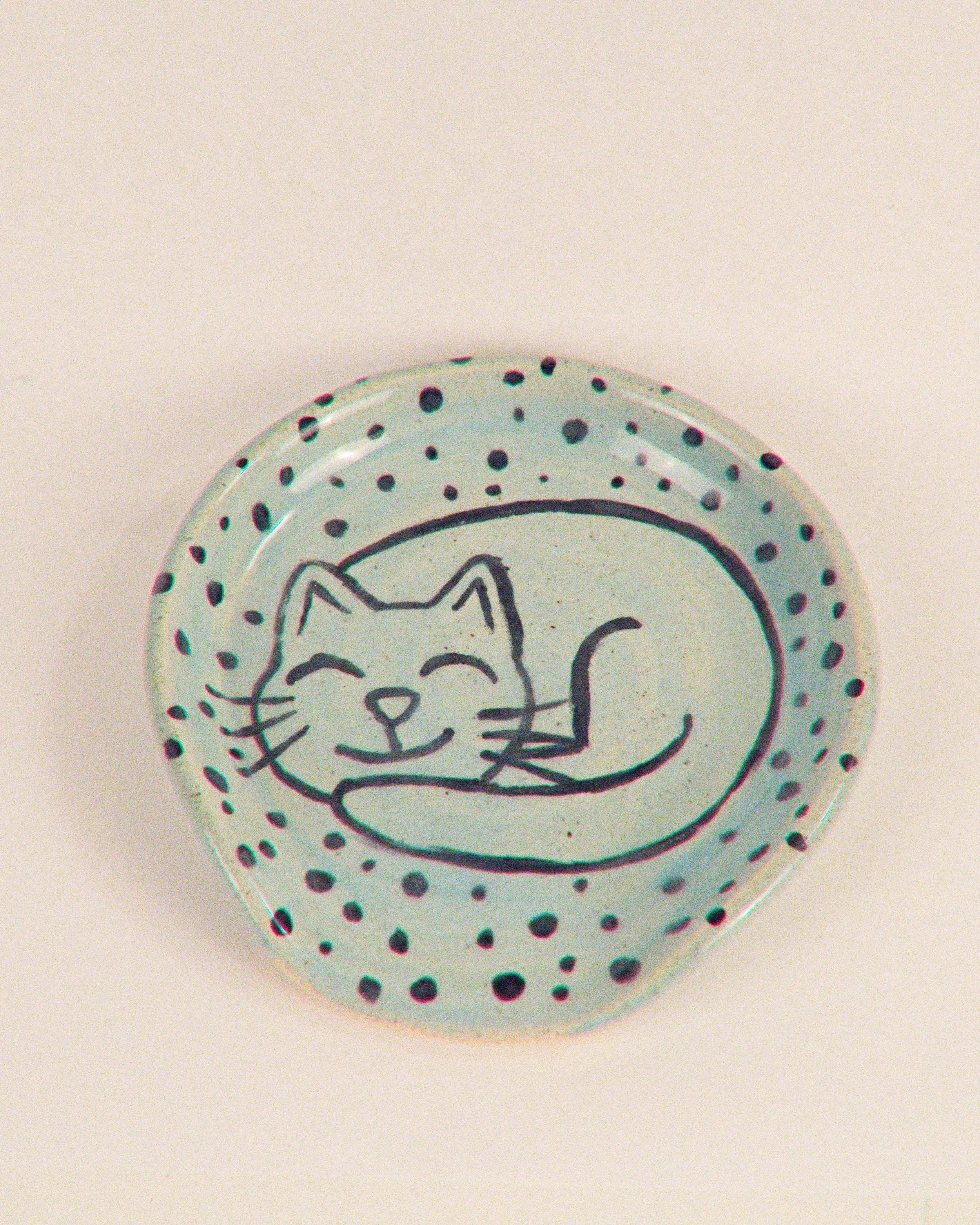 Light blue pottery spoon rest with a black cat and polka dots. 
