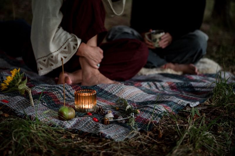 Seasonal outdoor gathering with candles, flowers and a picnic blanket in the Scottish countryside.