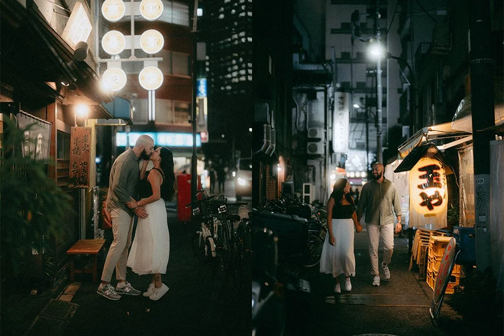 Couple sharing a kiss on a city street at night, with a young woman and man walking nearby in a dark alleyway illuminated by streetlights and signs, on a quiet urban night.