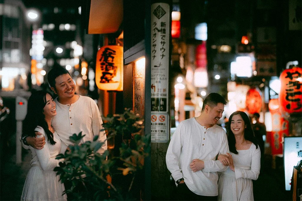 A couple enjoying themselves on a night out in a busy, illuminated street with traditional Japanese lanterns and signs. They are dressed in white, smiling, and sharing a happy moment.