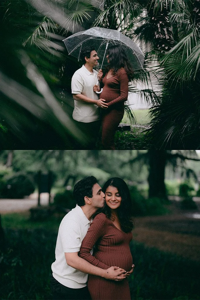 A man and woman stand outdoors under an umbrella in a lush, green garden. The man is smiling and holding the umbrella while the woman, who is pregnant, is gently touching her belly and smiling at him. In the second photo, the couple is close, with th