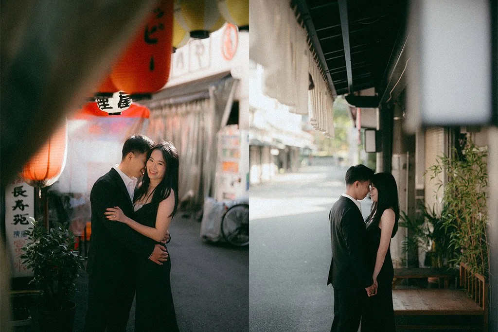 A young couple in formal attire sharing intimate moments in a narrow street with Asian decor, lanterns, and storefronts, one side brightly lit and the other shaded.