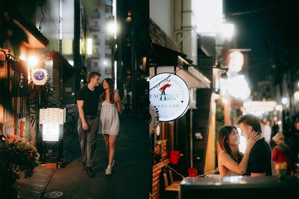 Couple walking arm-in-arm on a lit-up street at night in an urban area, with storefronts and neon signs