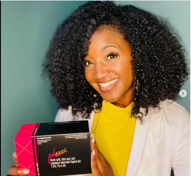 Woman smiling and holding a box of a product called Phexxi, which appears to be a vaginal gel.