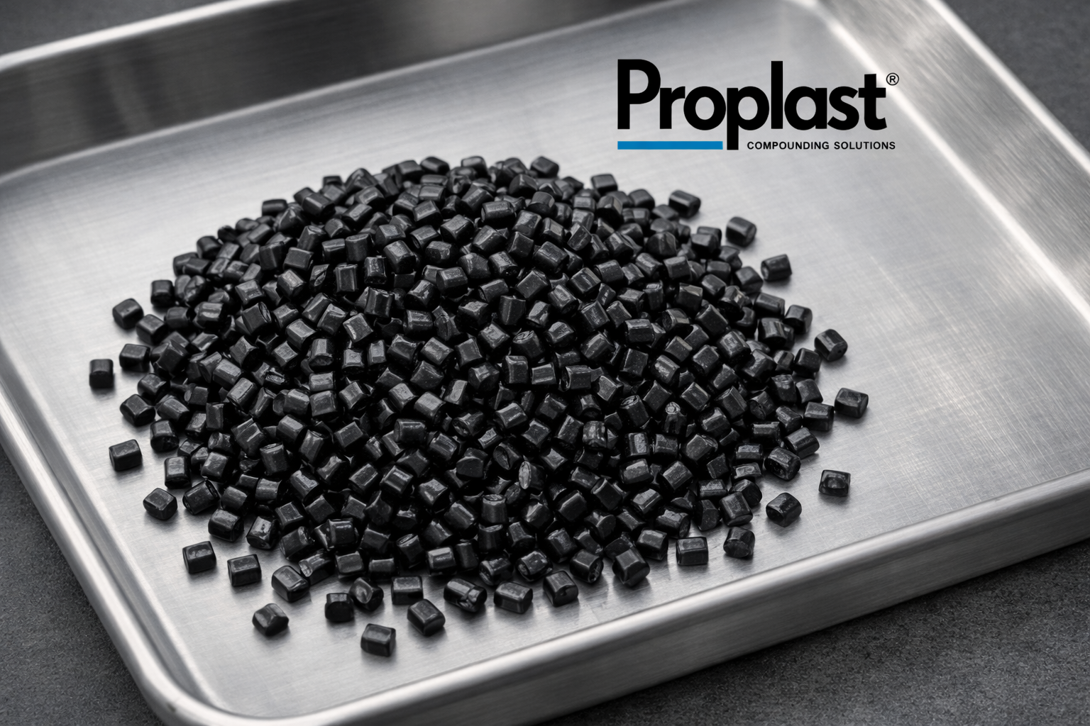 Pequeñas piezas negras en una bandeja de metal y el logotipo de Proplast.