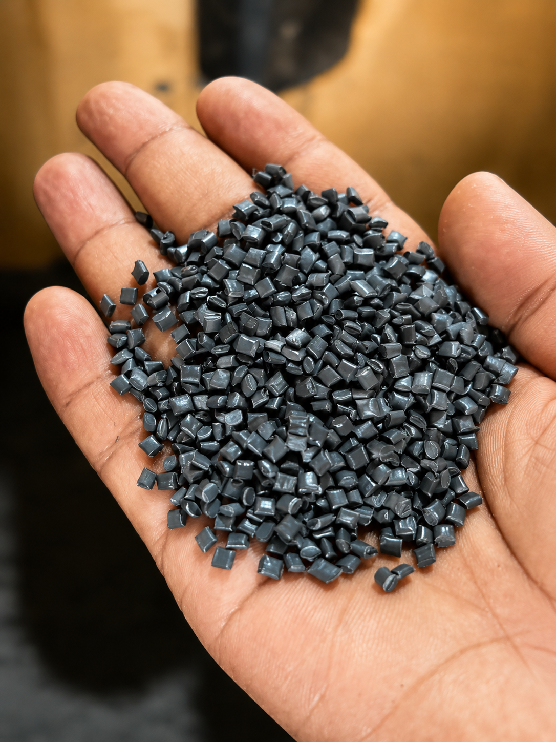 Mano sosteniendo pequeñas piezas negras de plástico.