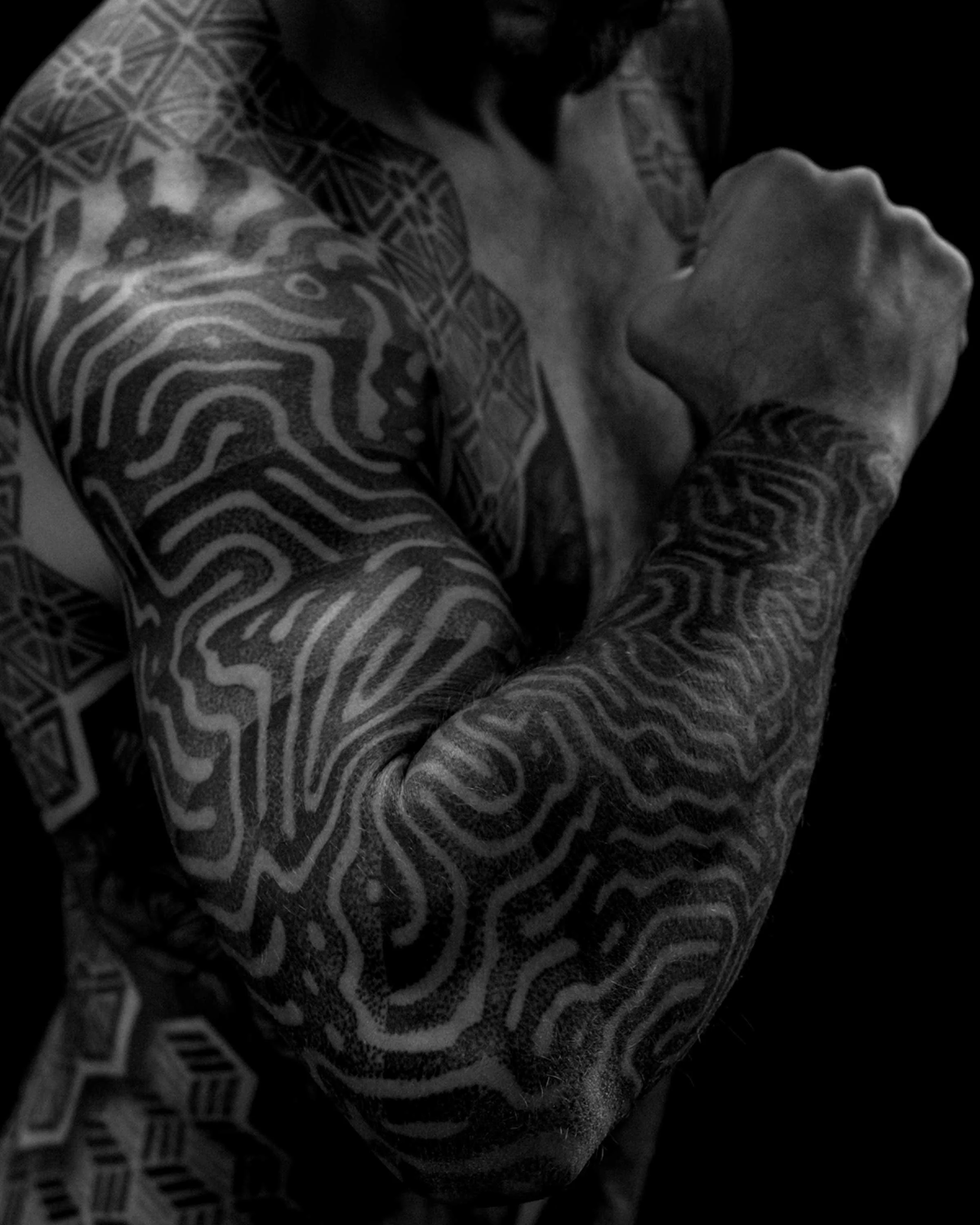Reaction Diffusion geometric sleeve tattoo by German tattoo artist Patrick Hüttlinger featuring flowing organic blackwork patterns across the entire arm.