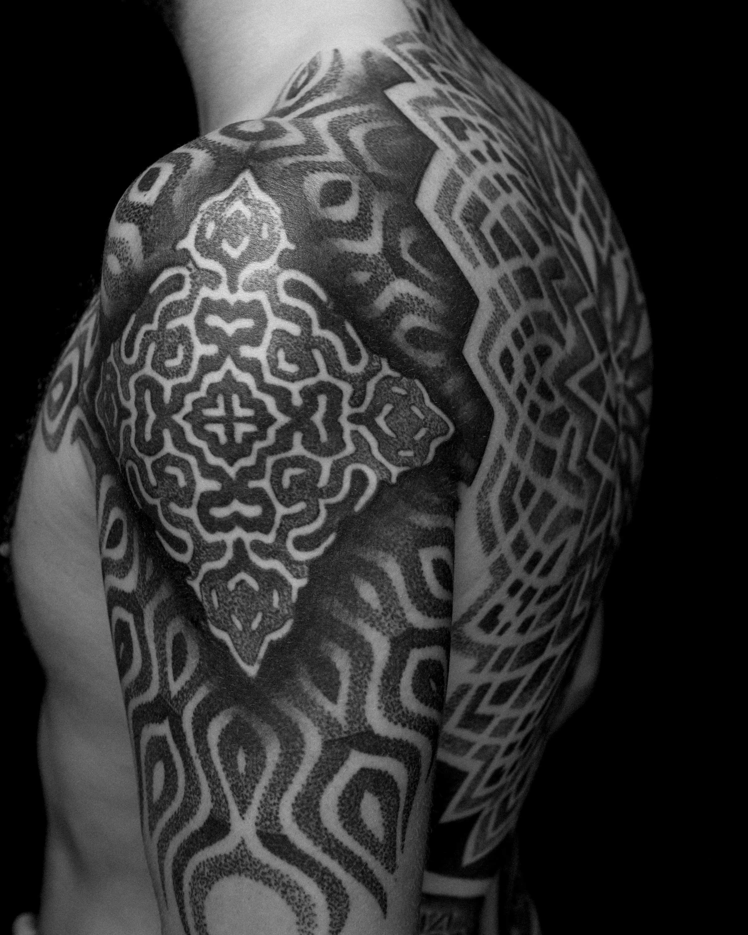 Reaction Diffusion upper arm tattoo by German tattoo artist Patrick Hüttlinger featuring sacred geometry, blackwork and flowing organic patterns.