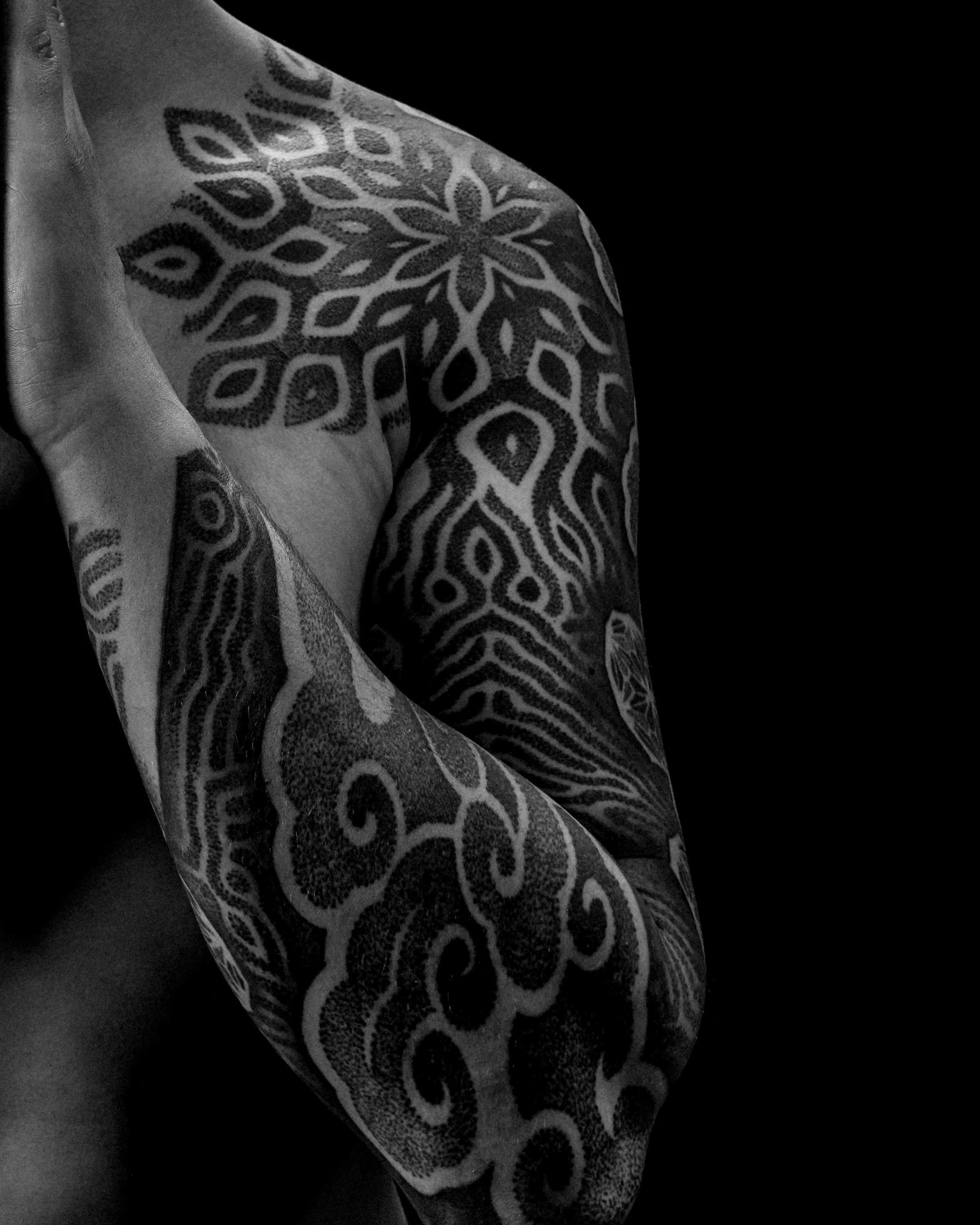 Reaction Diffusion upper arm tattoo by German tattoo artist Patrick Hüttlinger featuring sacred geometry, blackwork and flowing organic pattern structures.