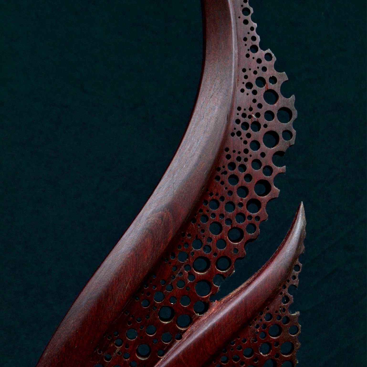 Detail view of the polished Nazareno hardwood grain and sculptural curves of Organika by Patrick Hüttlinger.