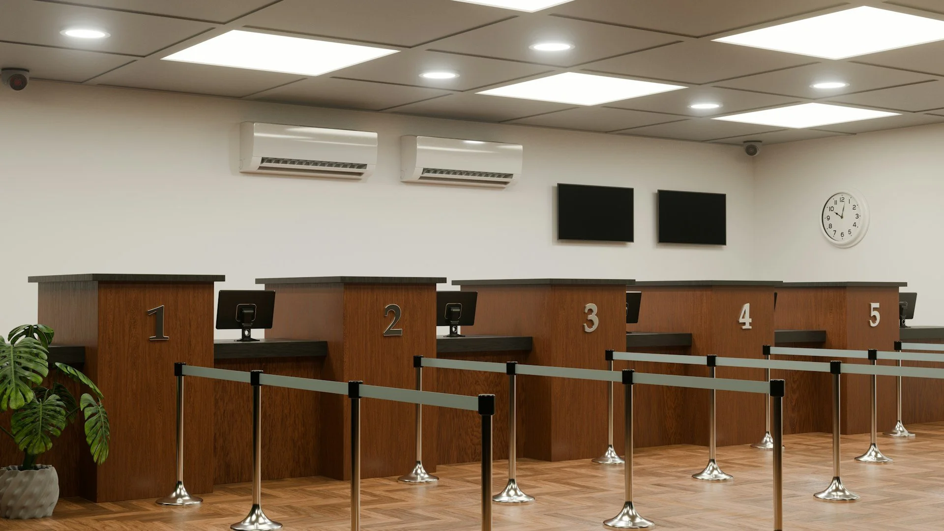 A bank or service counter area with five numbered desks, computer monitors, and barriers. There are two wall-mounted TVs, a clock showing 9:33, and air conditioning units on the wall.