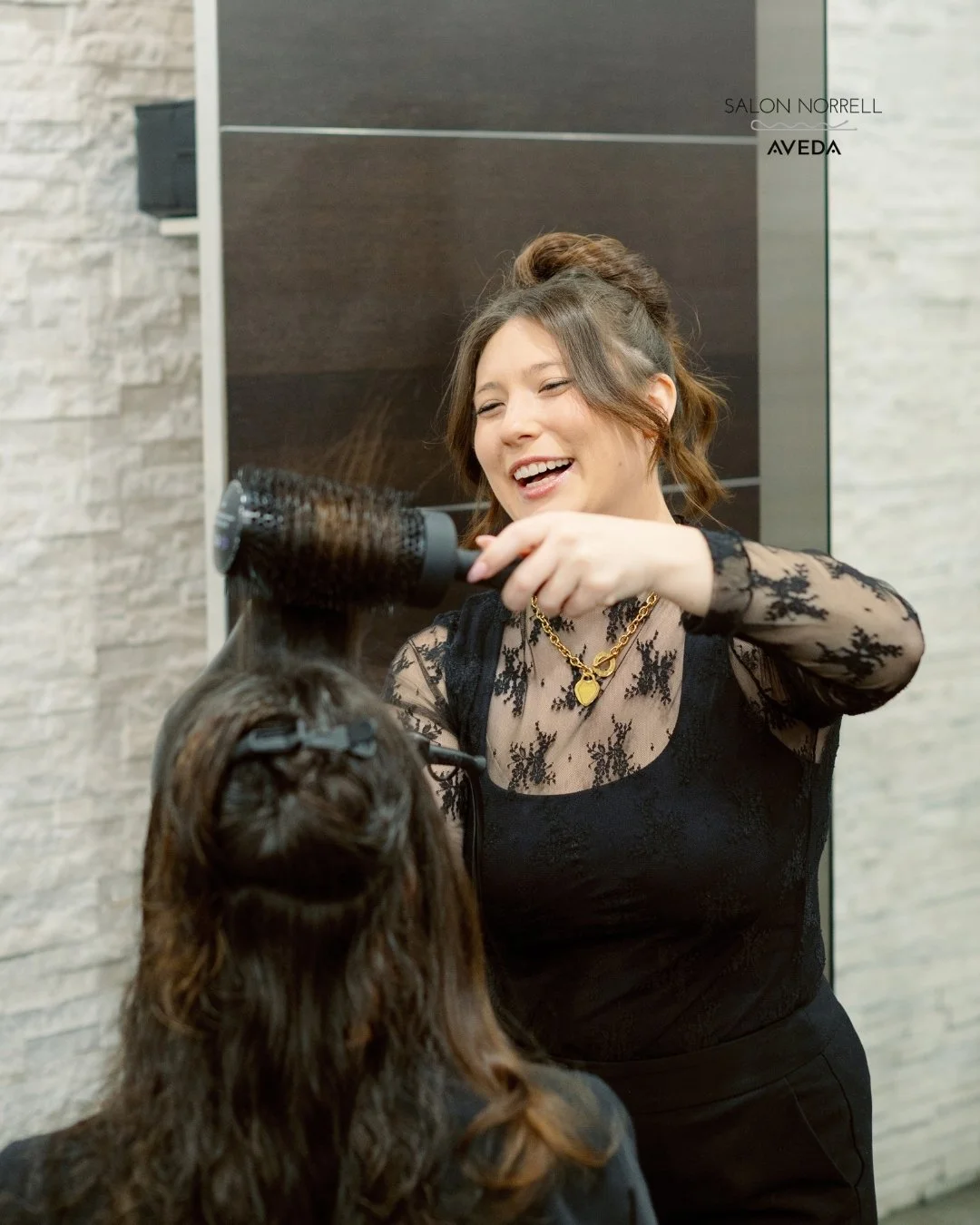 Brianne — balayage, dimensional haircolor, and blonding specialist at Salon Norrell AVEDA in Hyde Park Tampa doing a bouncy blowout