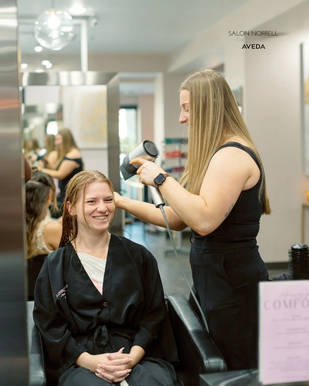 Emily — dimensional color, blonding, and extension specialist at Salon Norrell AVEDA in Hyde Park Tampa doing a bouncy blowout