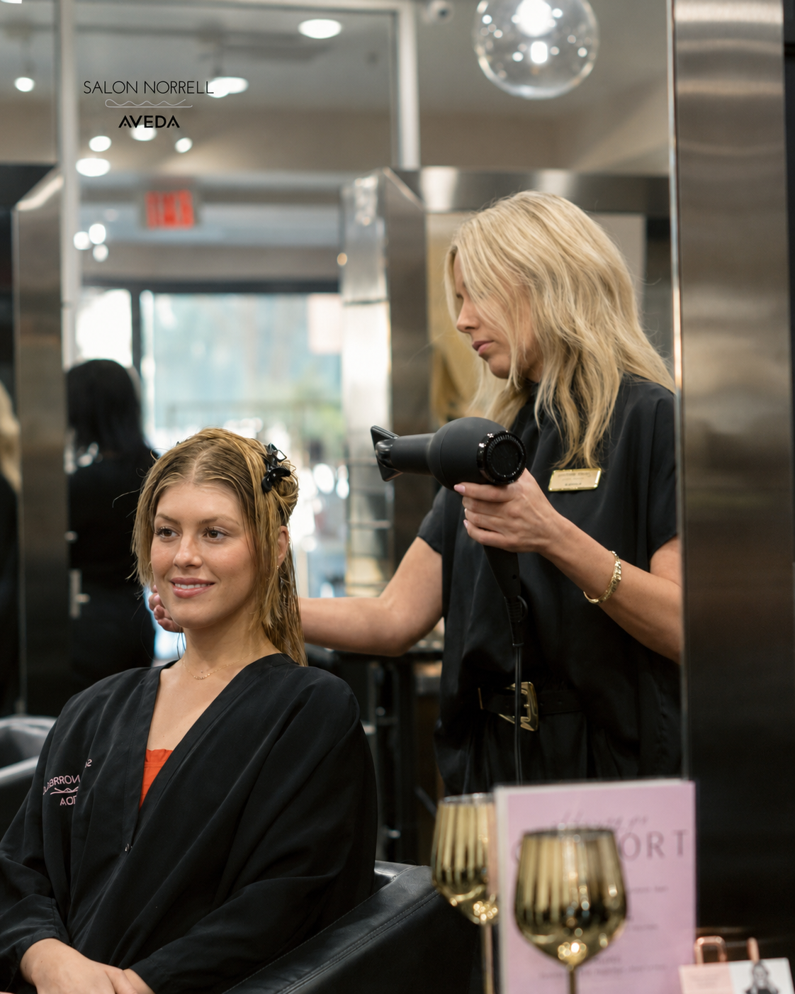 Sarah — blonding, dimensional brunette, and balayage specialist at Salon Norrell AVEDA in Hyde Park Tampa doing a bouncy blowout