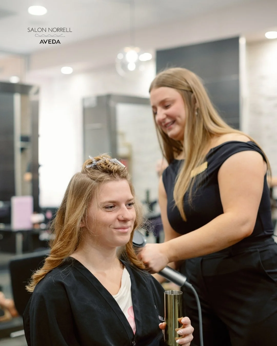 Emily — dimensional color, blonding, and extension specialist at Salon Norrell AVEDA in Hyde Park Tampa doing a bouncy blowout