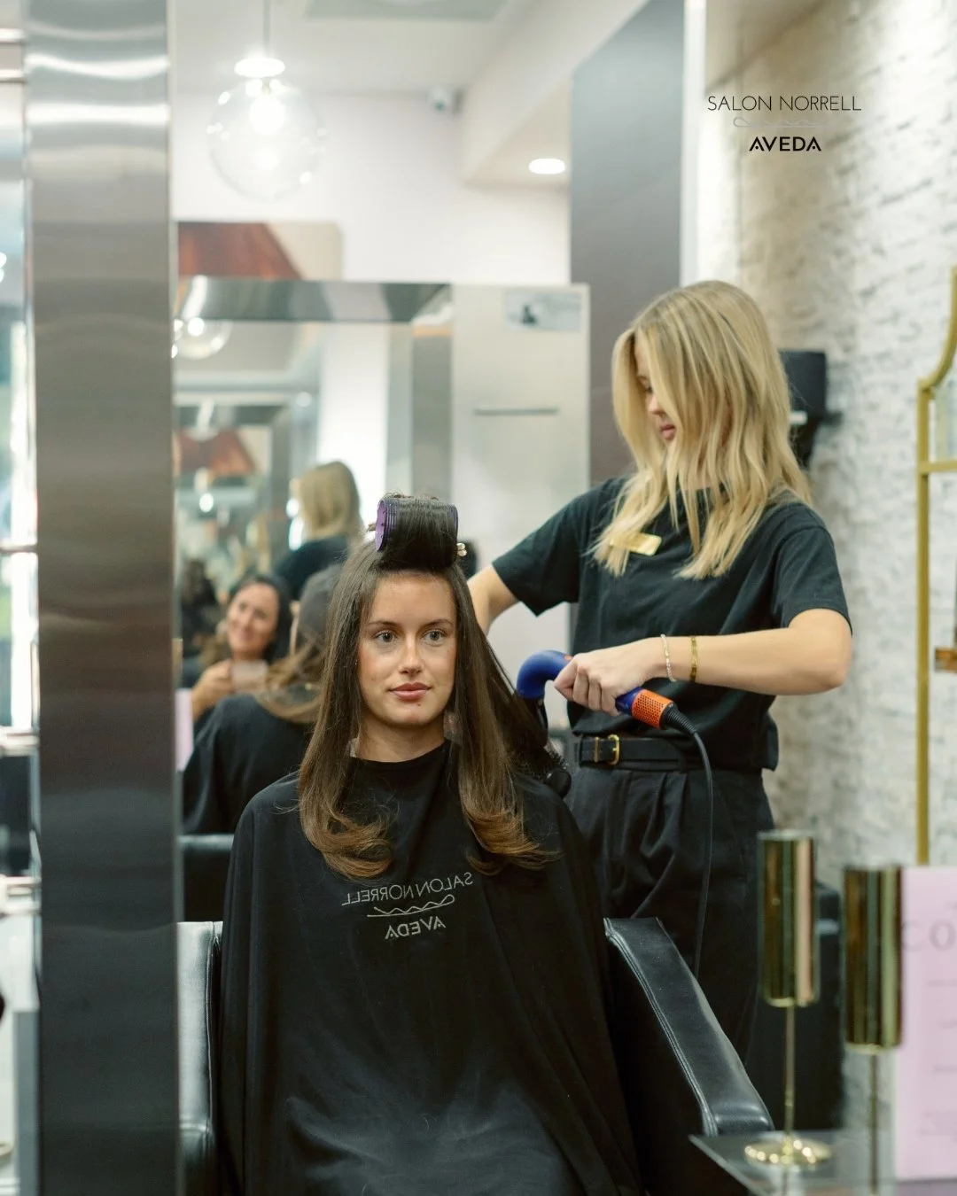 Madison — lived-in color, beachy blonding, and balayage specialist at Salon Norrell AVEDA in Hyde Park Tampa doing a bouncy blowout