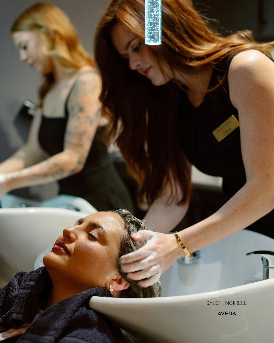 Allyson — lived-in color, blonding, and precision haircut specialist at Salon Norrell AVEDA in Carrollwood Tampa doing a scalp massage ritual