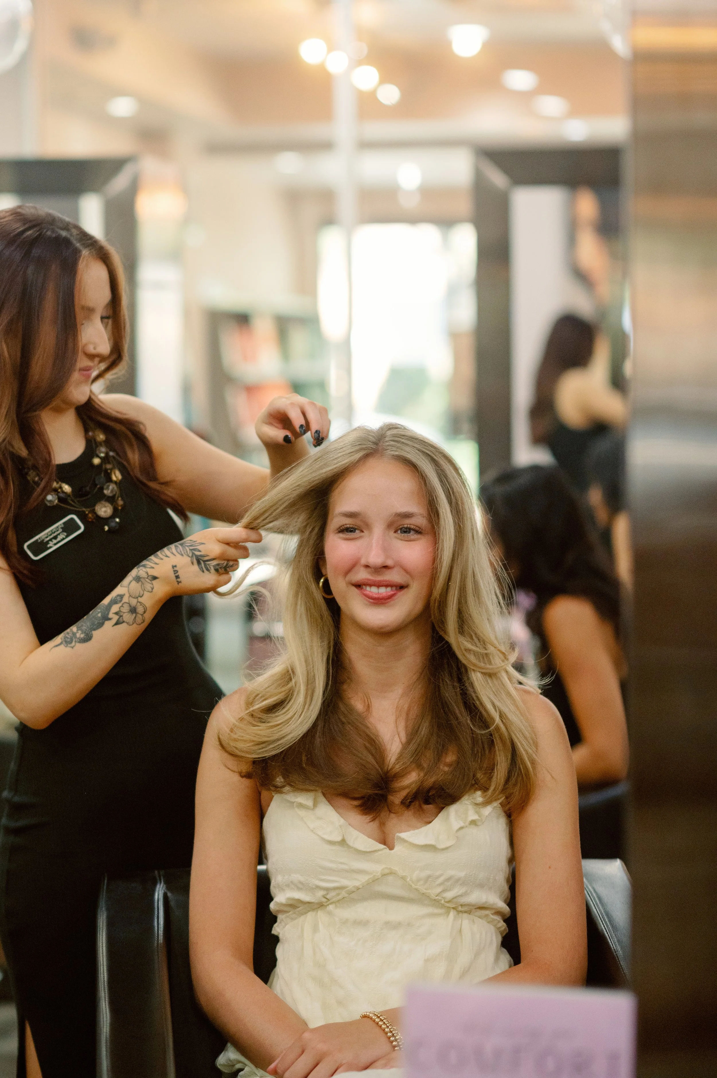 Madalyn — fashion color, curly hair, and dimensional blonding specialist at Salon Norrell AVEDA in Hyde Park Tampa doing a bouncy blowout