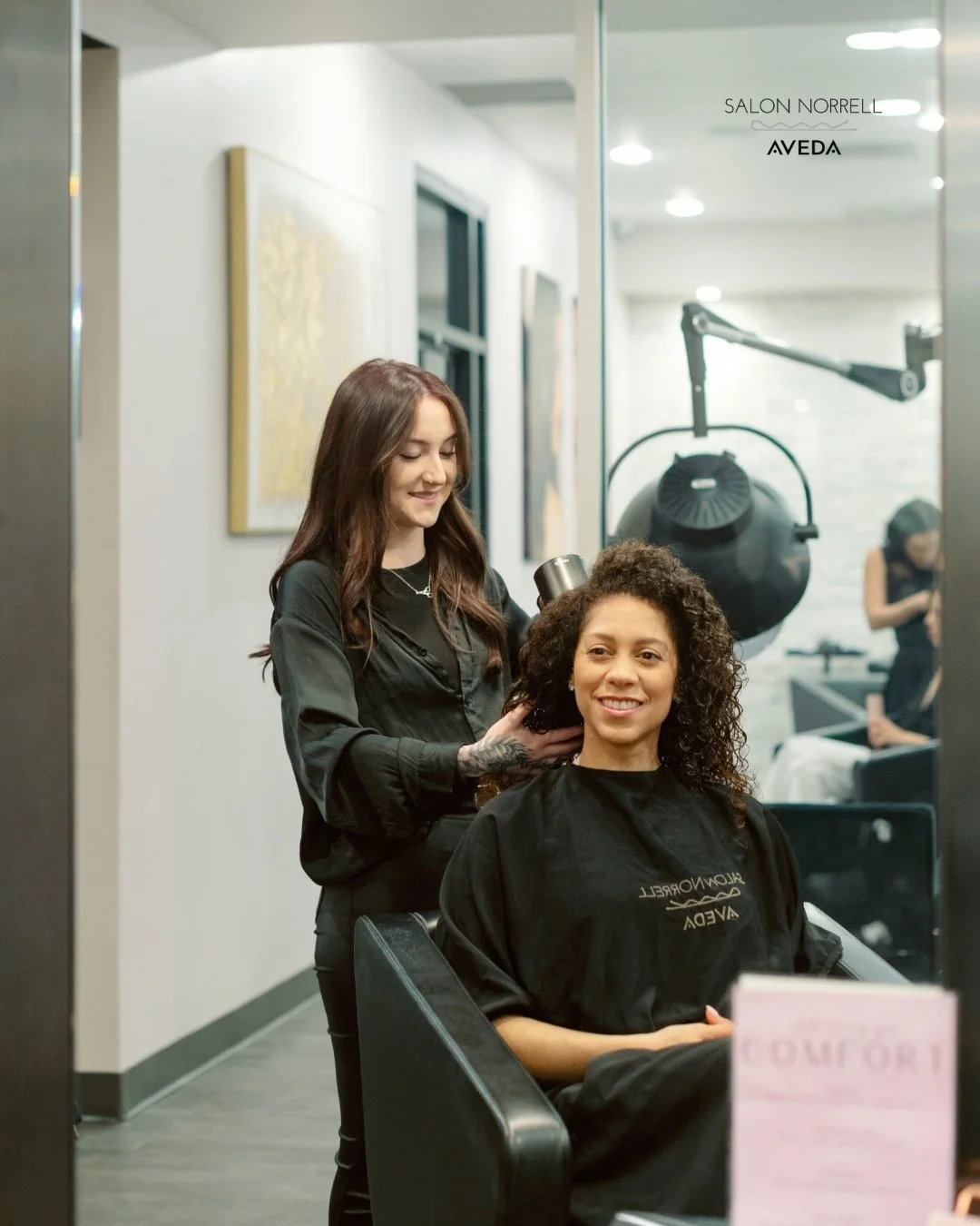 Madalyn — fashion color, curly hair, and dimensional blonding specialist at Salon Norrell AVEDA in Hyde Park Tampa doing a curly style with diffuser