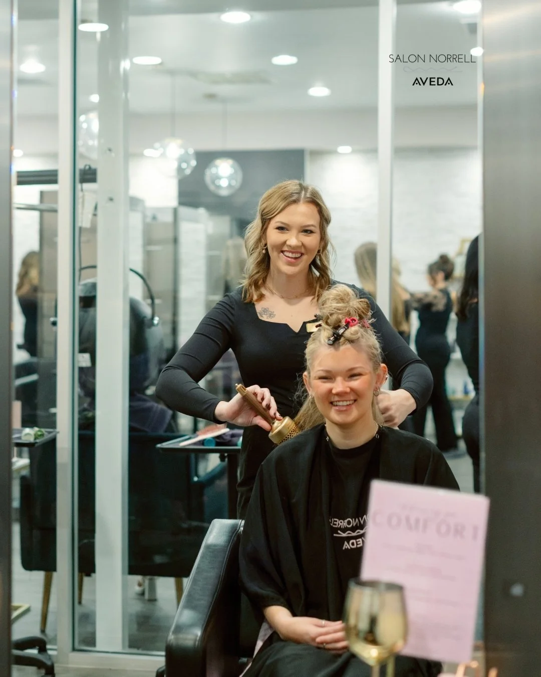 Alaina — blonding, corrective color, and dimensional blonding specialist at Salon Norrell AVEDA in Hyde Park Tampa doing a bouncy blowout on model