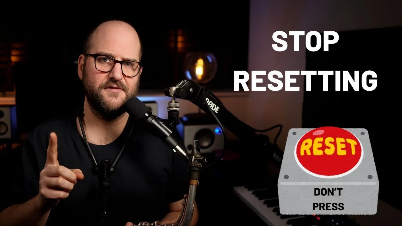 Mike Chillingwo pointing his finger upward, with a microphone in front of him. On the right side, there is a large text that says "STOP RESETTING" and a graphic of a reset button with the words "RESET DON'T PRESS" on it.