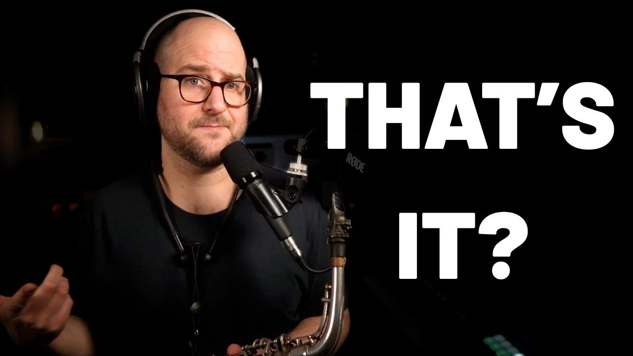 A man wearing glasses and headphones standing in front of a microphone with the text 'That's it?' on a black background.
