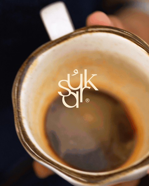 Top view of a coffee mug filled with dark coffee, with a partially visible handle and a logo overlay.