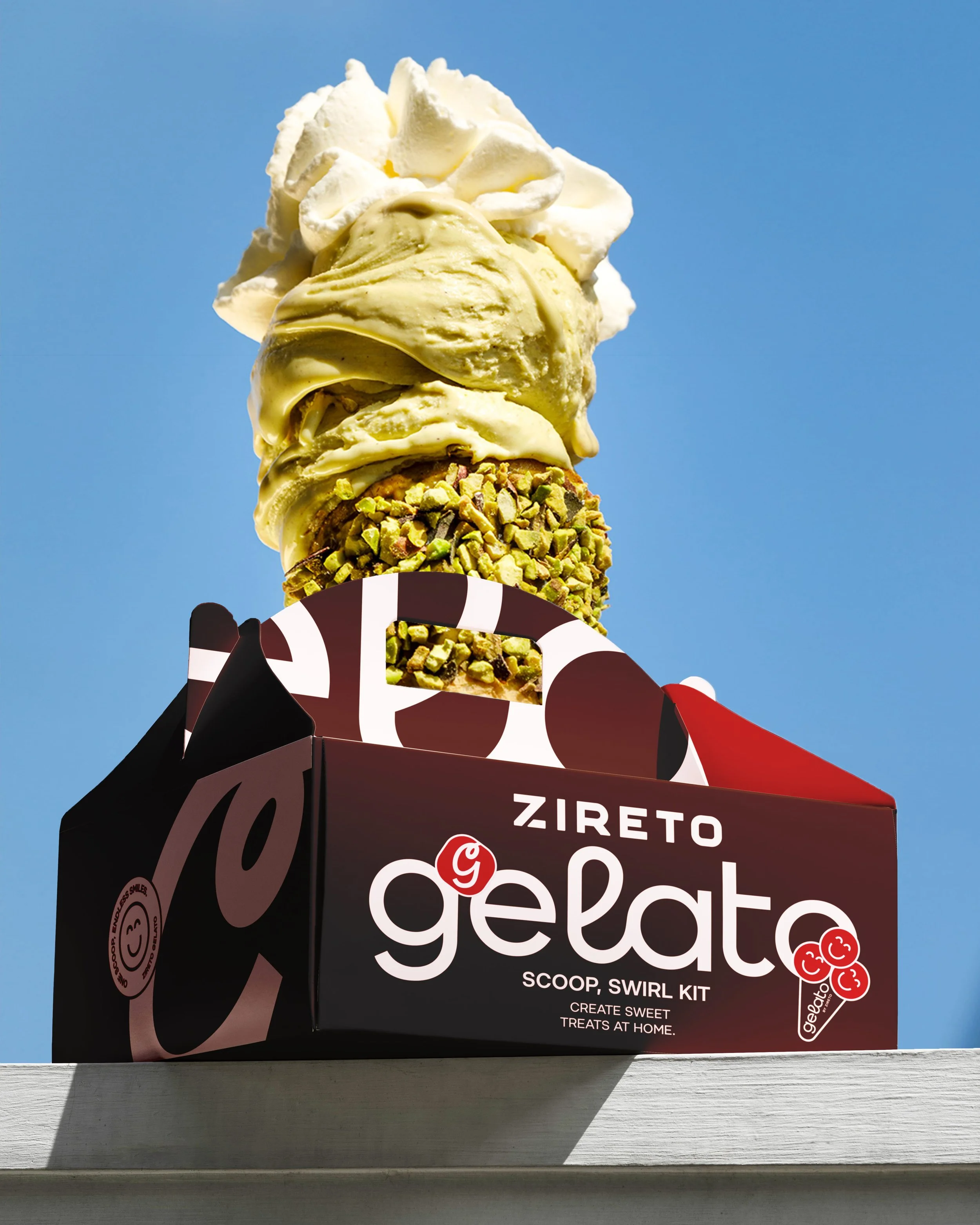 A box of sweet treats called 'Gigita' with a scoop of vanilla ice cream topped with whipped cream on a blue sky background, placed on a white surface.