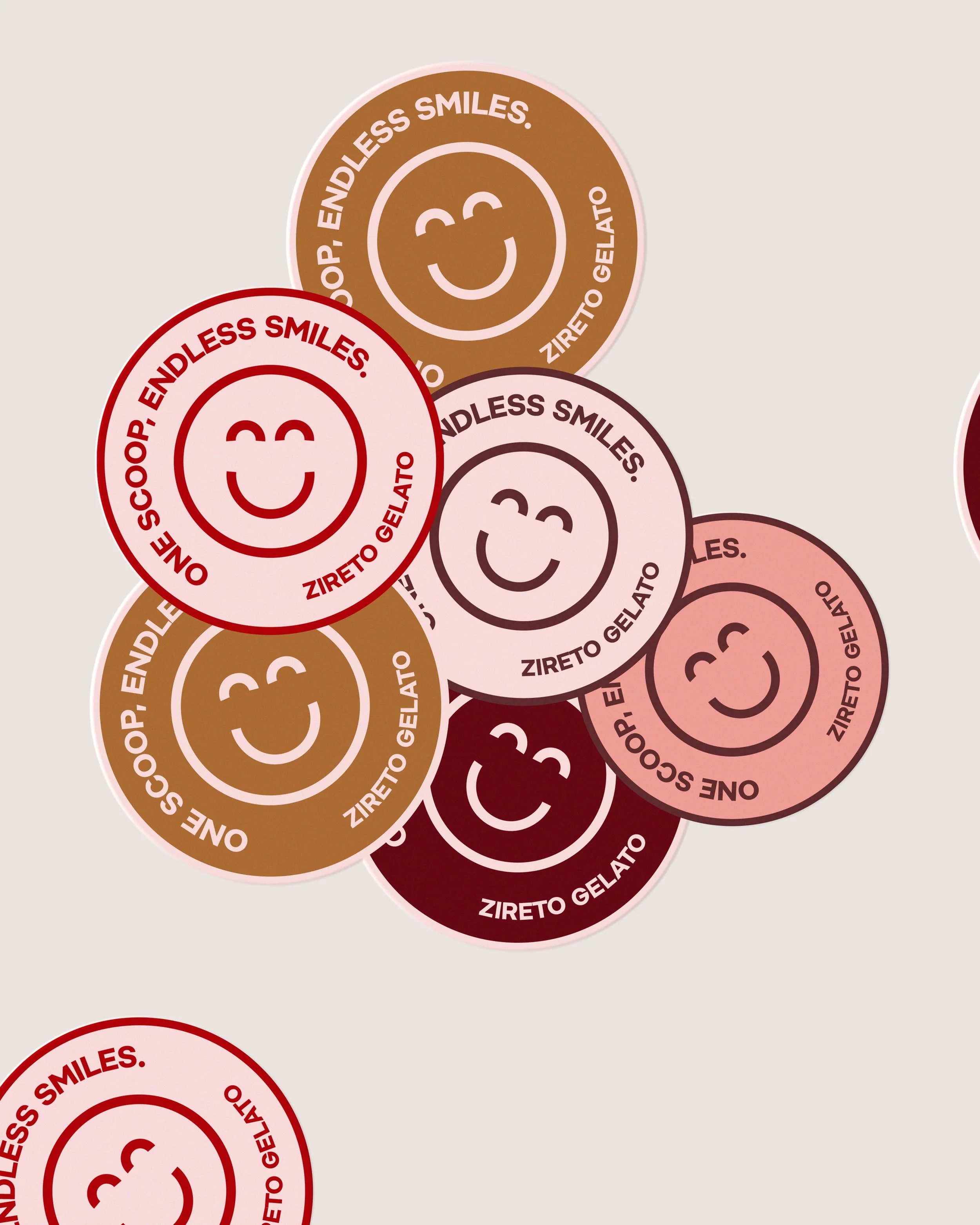 Several colorful circular stickers with smiley faces and the phrase "ONE SCOOP. ENDLESS SMILES." in both English and Italian, ZIRTEO GELATO, arranged overlapping on a neutral background.