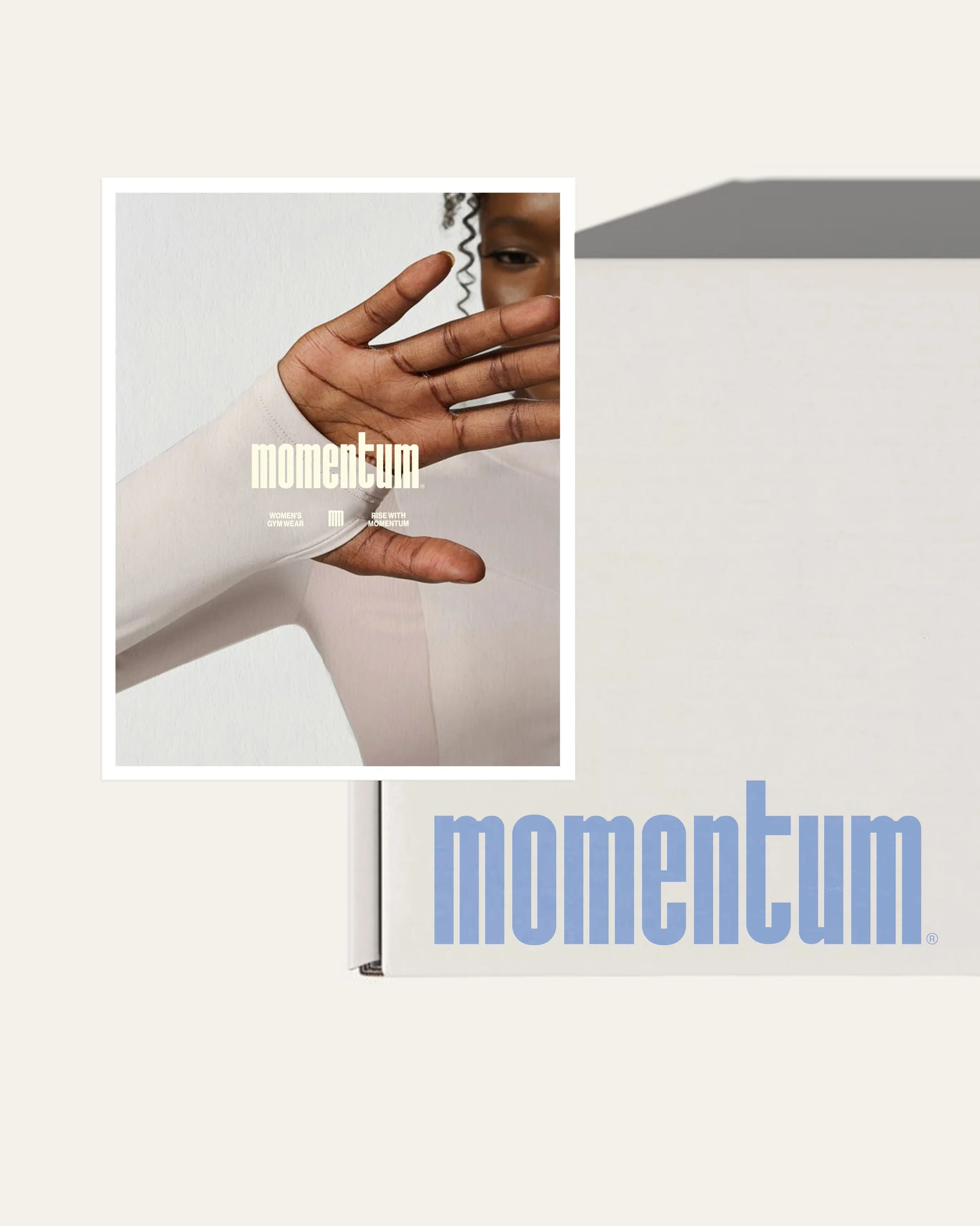 The image shows a magazine titled 'momentum' held in front of a wall. The magazine cover features a close-up photo of a person's hand partially covering their face, with the person's eye and part of their curly hair visible. The magazine has text that reads 'WOMEN'S GYM WEAR' and 'RISE WITH MOMENTUM'.
