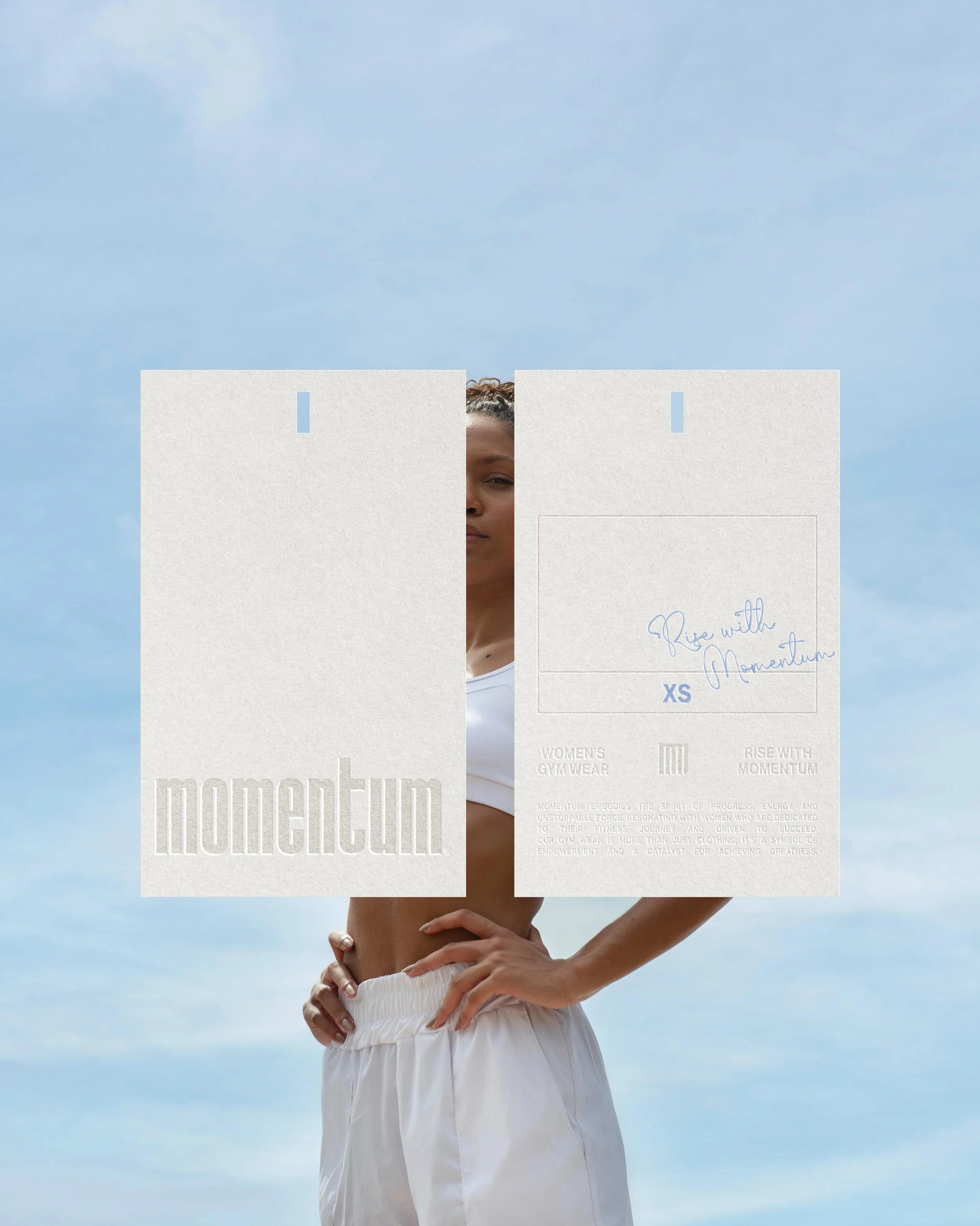 Person standing outdoors holding a white sign that reads "Rise with Momentum" and "XS" with a cloud-filled sky in the background.