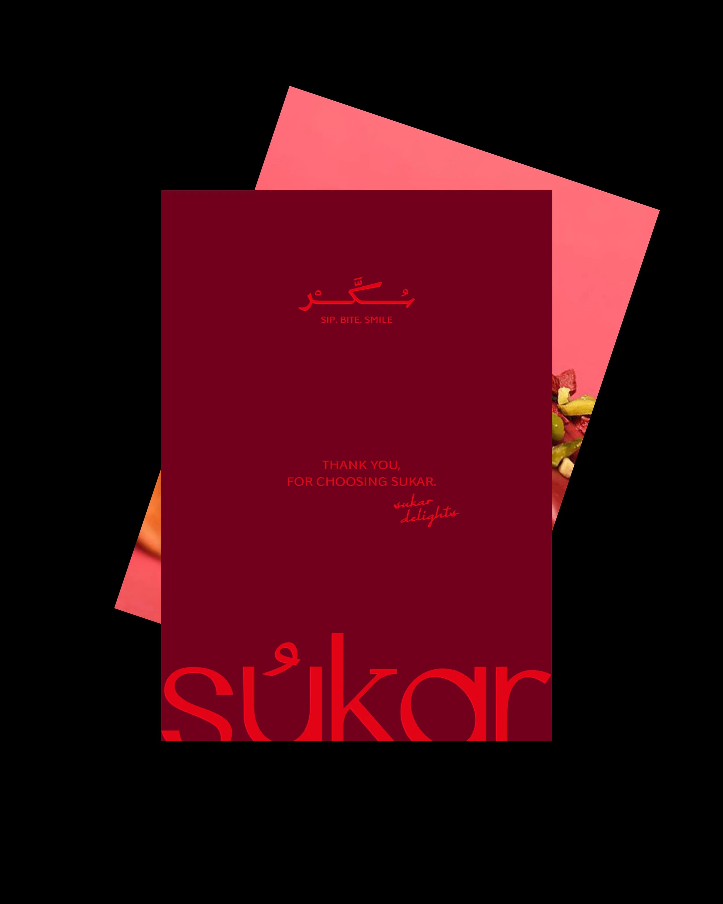 A red gift card with the name 'Sukar' written in Arabic and English, and the phrases 'Sip. Bite. Smile' and 'Thank you for choosing Sukar.' There is a background with pink and some fruit images.