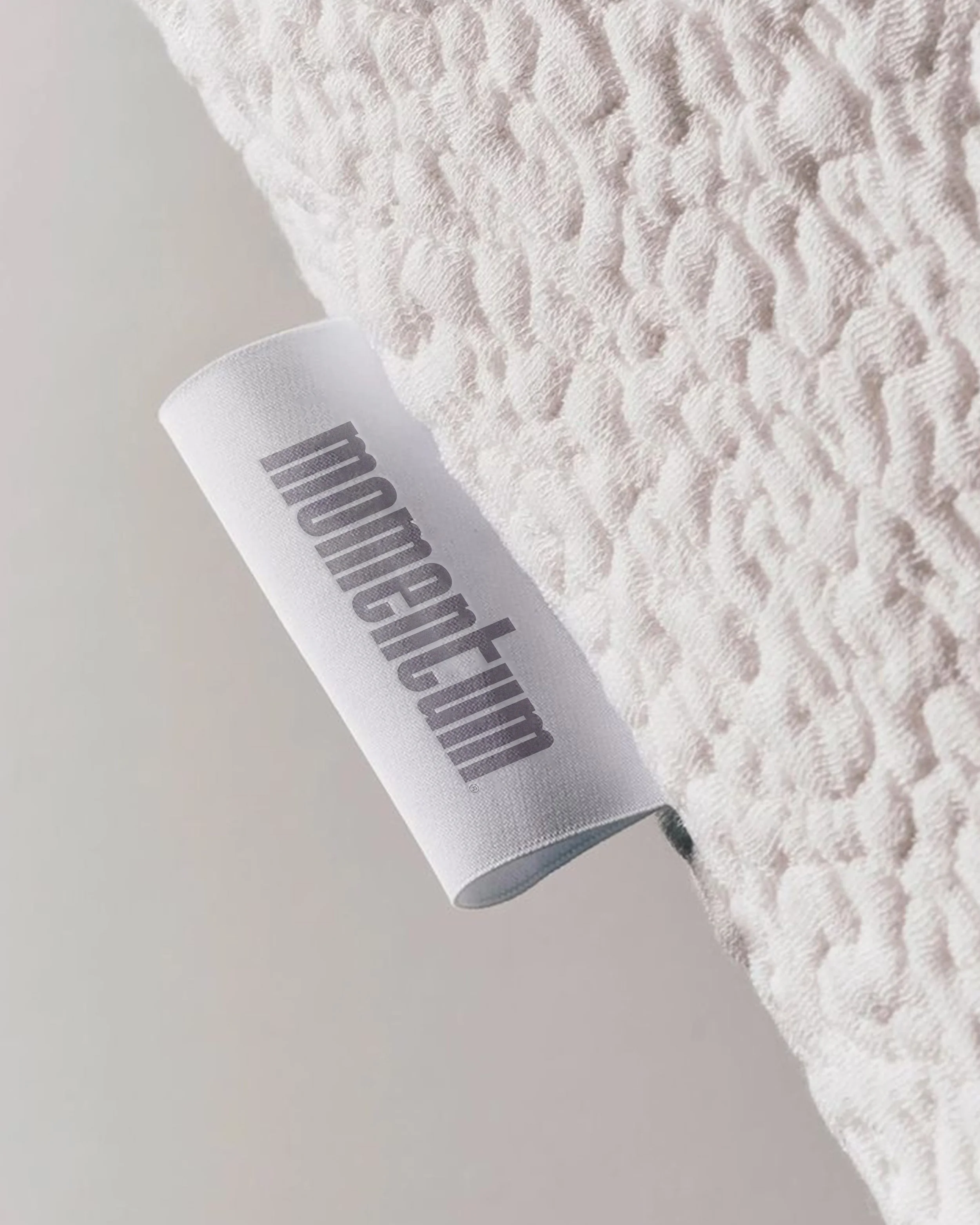 Close-up of a white textured towel with a label partially visible.