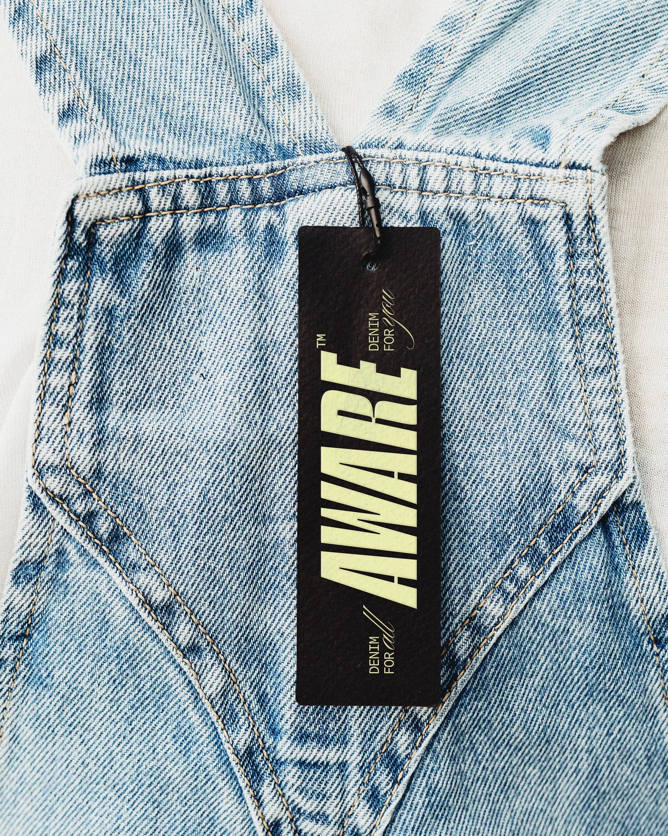 Close-up of a pair of light blue denim jeans with a black tag that says 'AUTHORIZED' attached at the waistband.