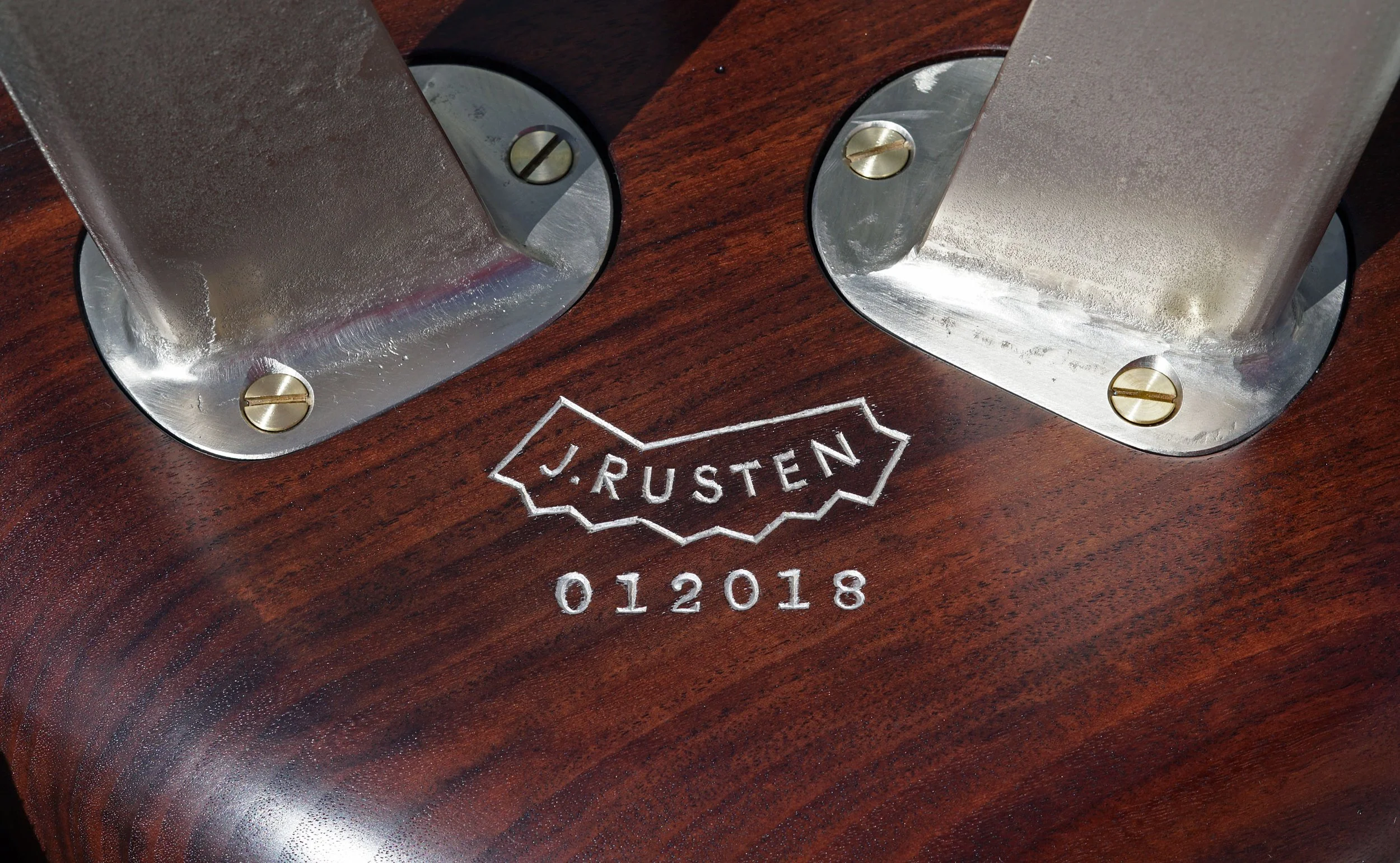 Close-up of reference marks and screws on a wooden surface with the logo 'J. Rusten' and the year '2018' engraved.