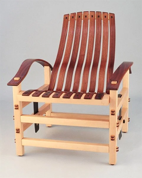 Miniature wooden armchair with slatted backrest and seat.