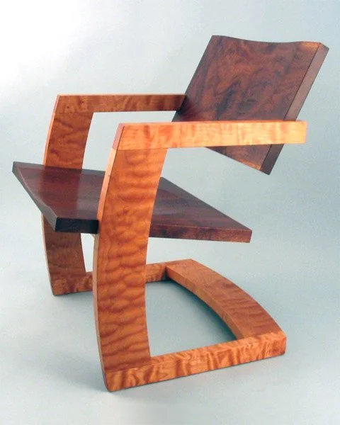 A wooden modern chair with curved armrests and a backrest, set against a plain background.