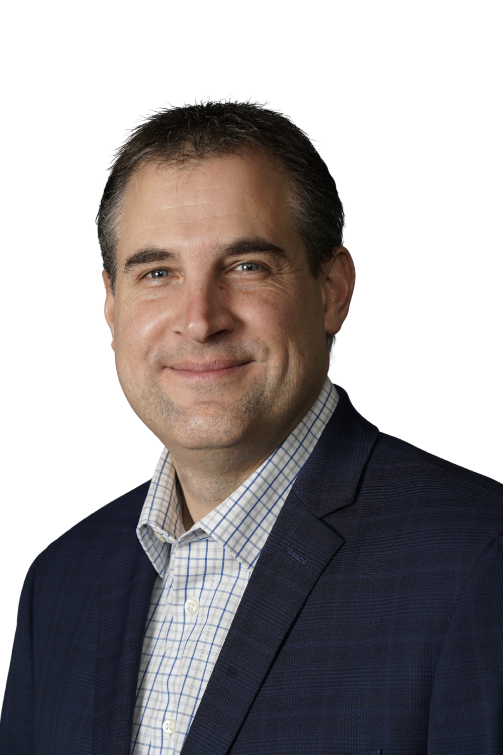 Jim Kozikci, wearing a navy blue blazer and a checkered dress shirt, smiling at the camera.