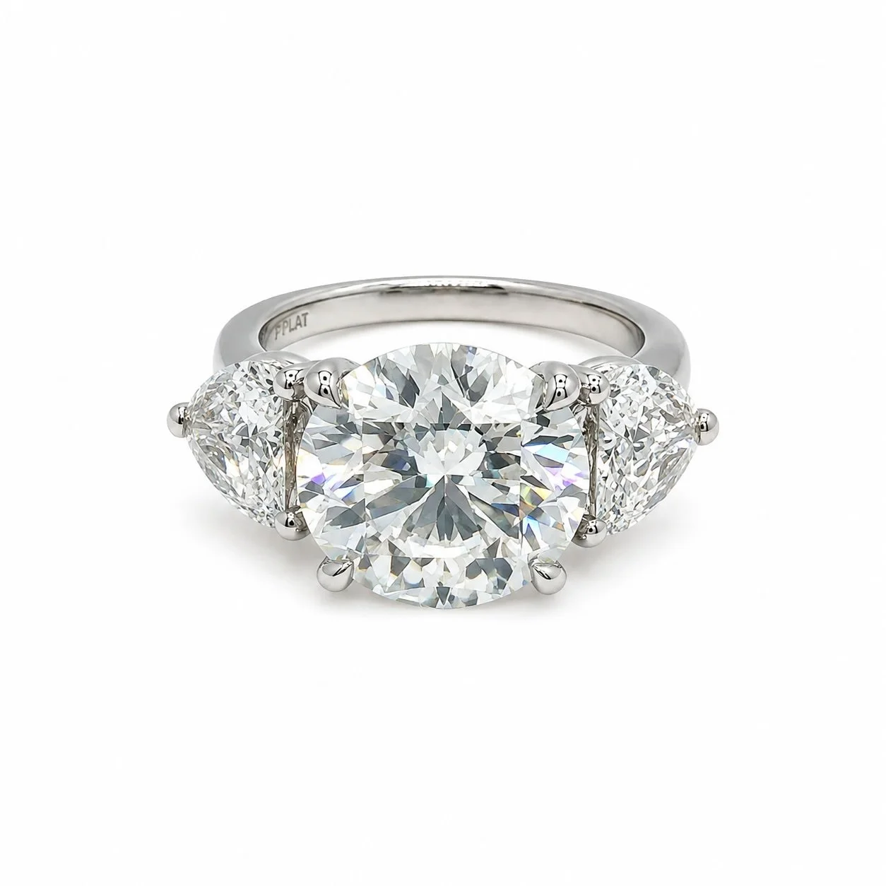 Diamond ring with a large central stone flanked by two smaller stones on a platinum band.
