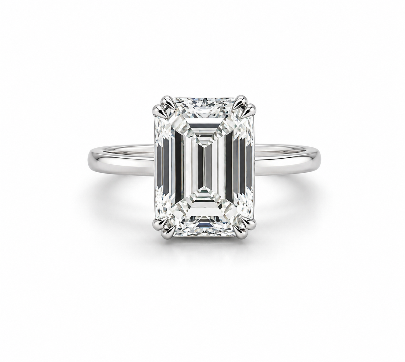 A platinum ring with a large rectangular emerald-cut diamond center stone in a four-prong bezel setting with an invisible baguette halo.