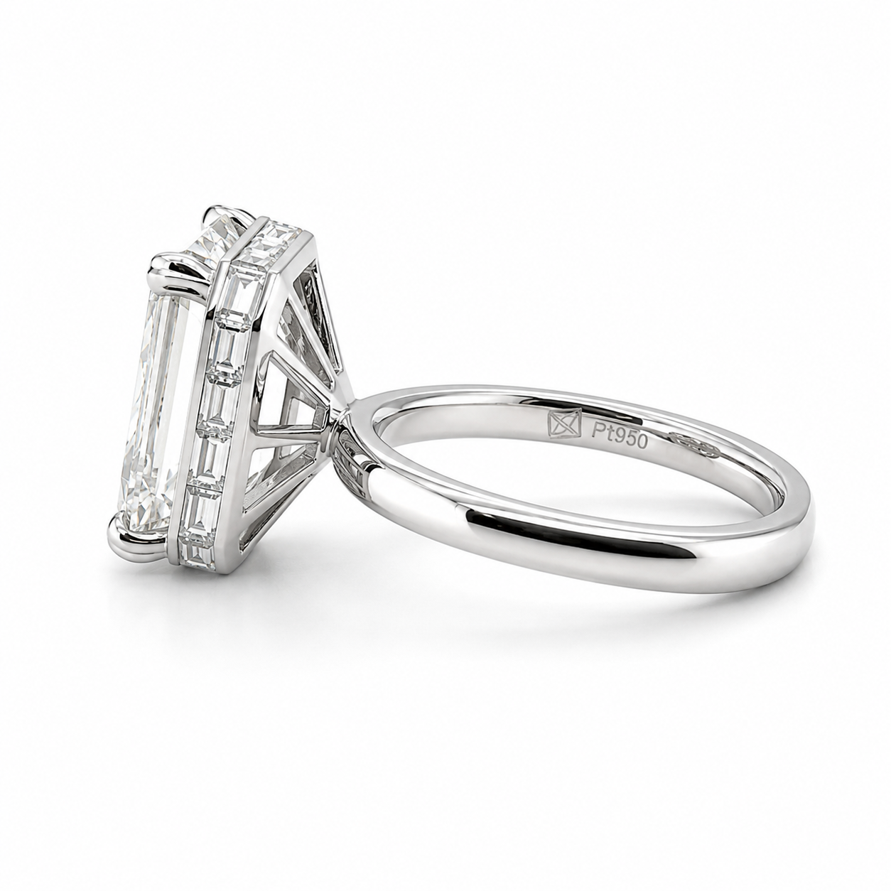 A platinum ring with a large rectangular emerald-cut diamond center stone in a four-prong bezel setting with an invisible baguette halo.