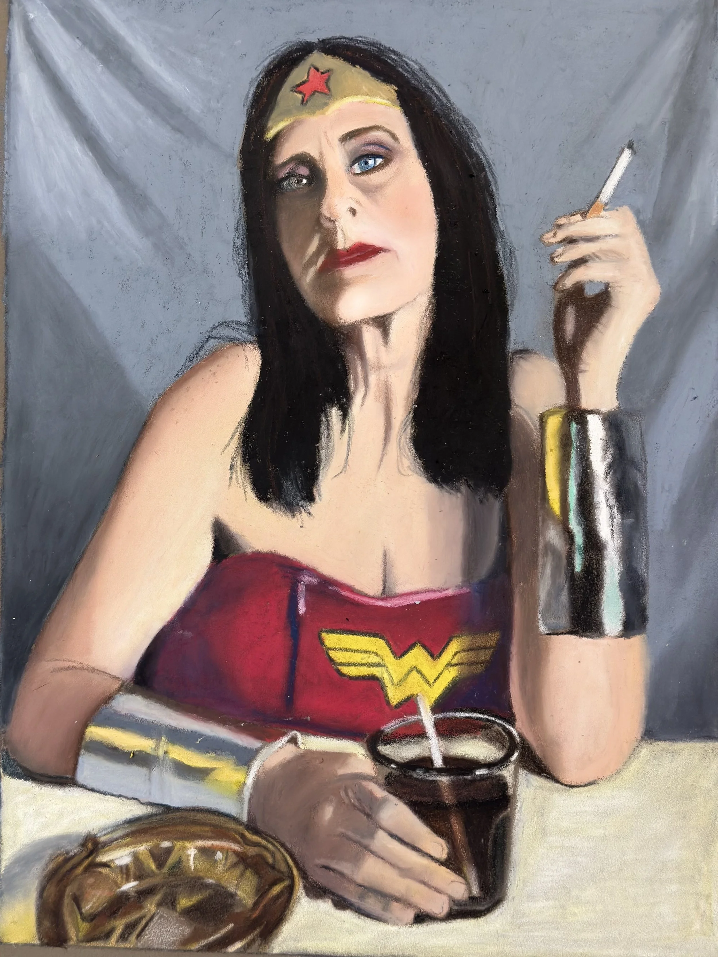 A woman dressed as Wonder Woman, wearing a headband with a red star, a Wonder Woman costume, holding a cigarette in her right hand, and reaching for a bowl of chocolate chips or M&Ms on the table.
