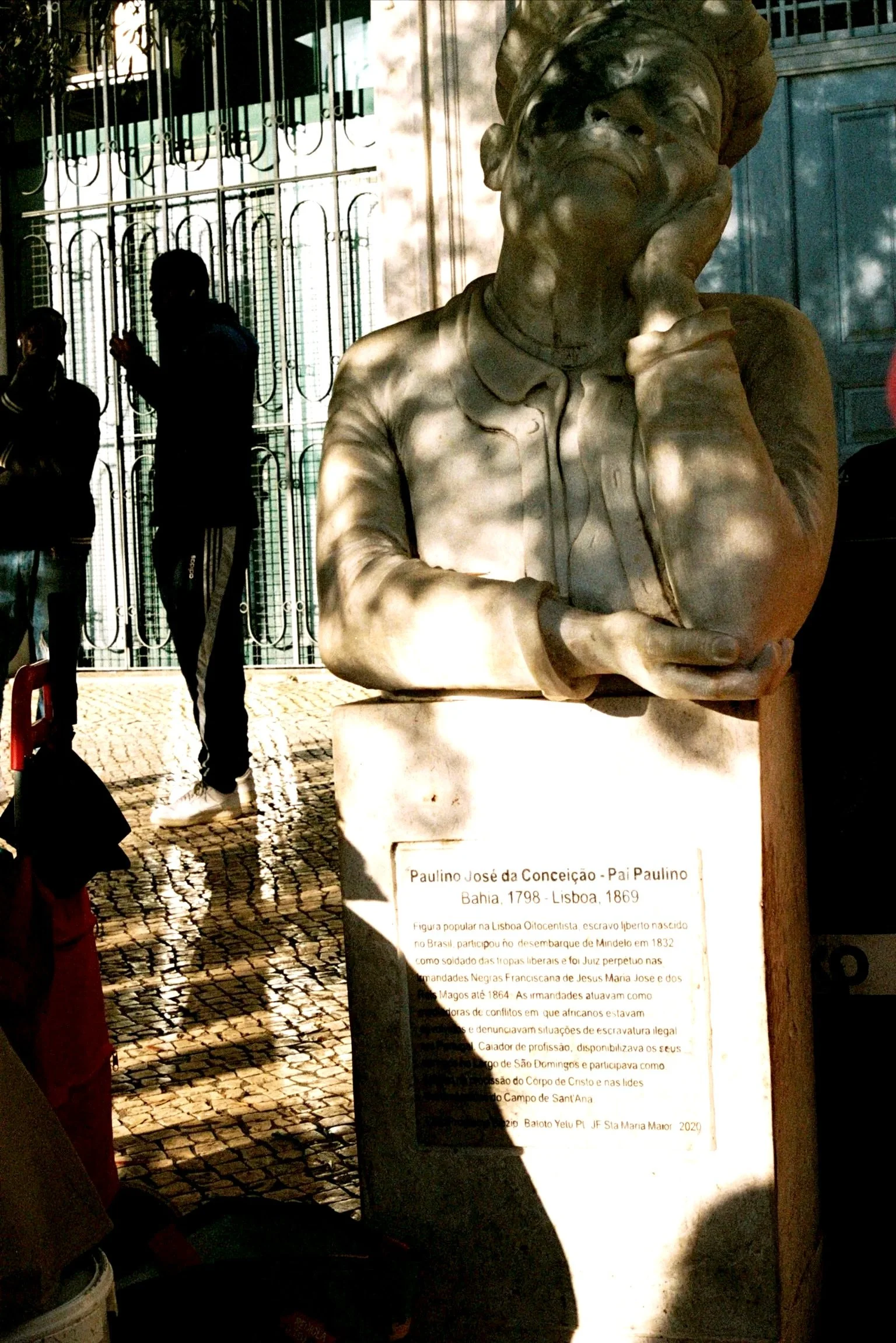 Bronze bust sculpture of Paulino José da Conceição, also known as Pai Paulino, a historical figure from Bahia, Brazil, created in 1869, displayed outdoors in Lisbon, Portugal.
