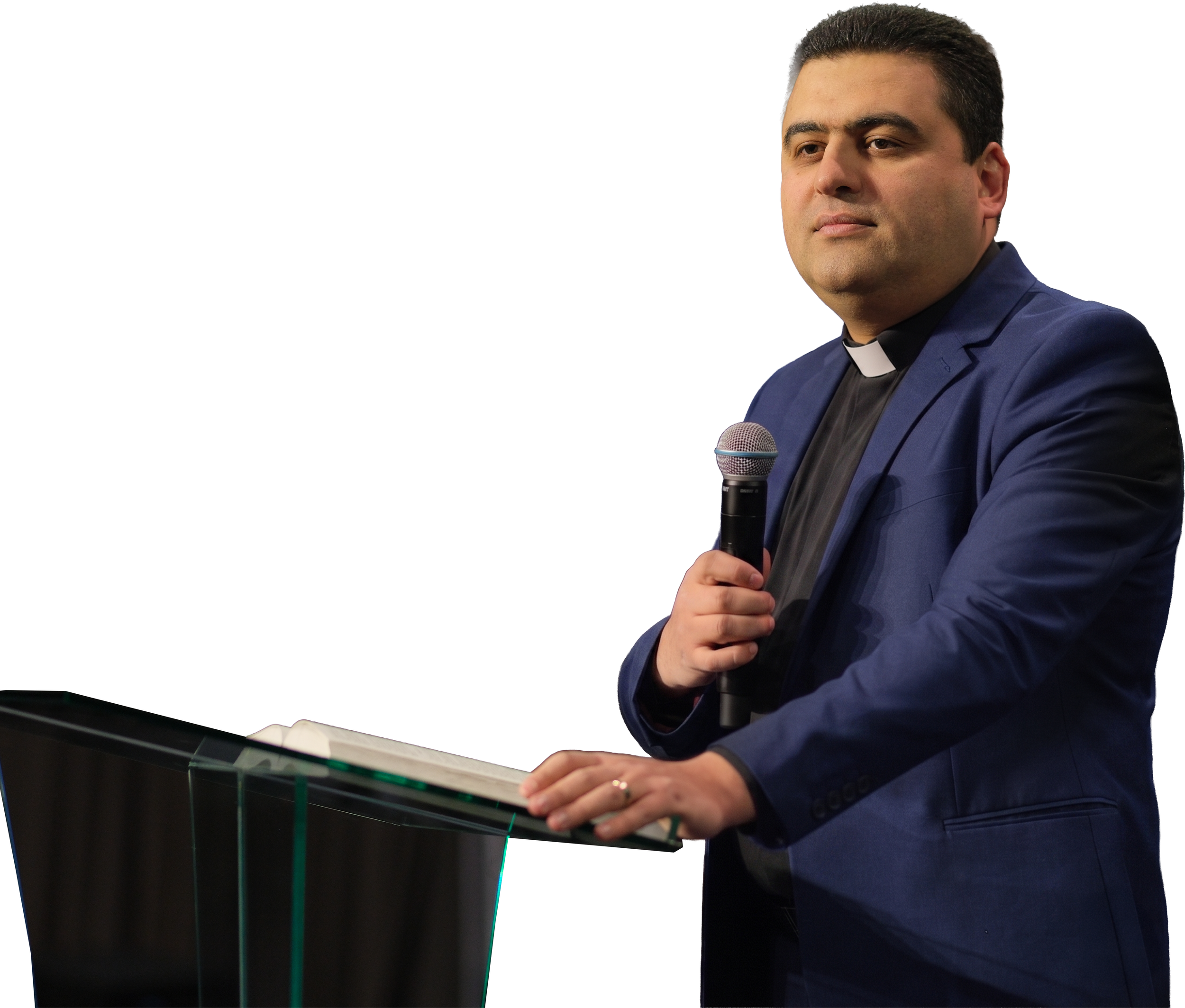 Կապույտ կոստյումով և գրասենյակային օձիքով տղամարդ՝ ամբիոնի մոտ միկրոֆոնը ձեռքին, սպիտակ ֆոնի վրա։